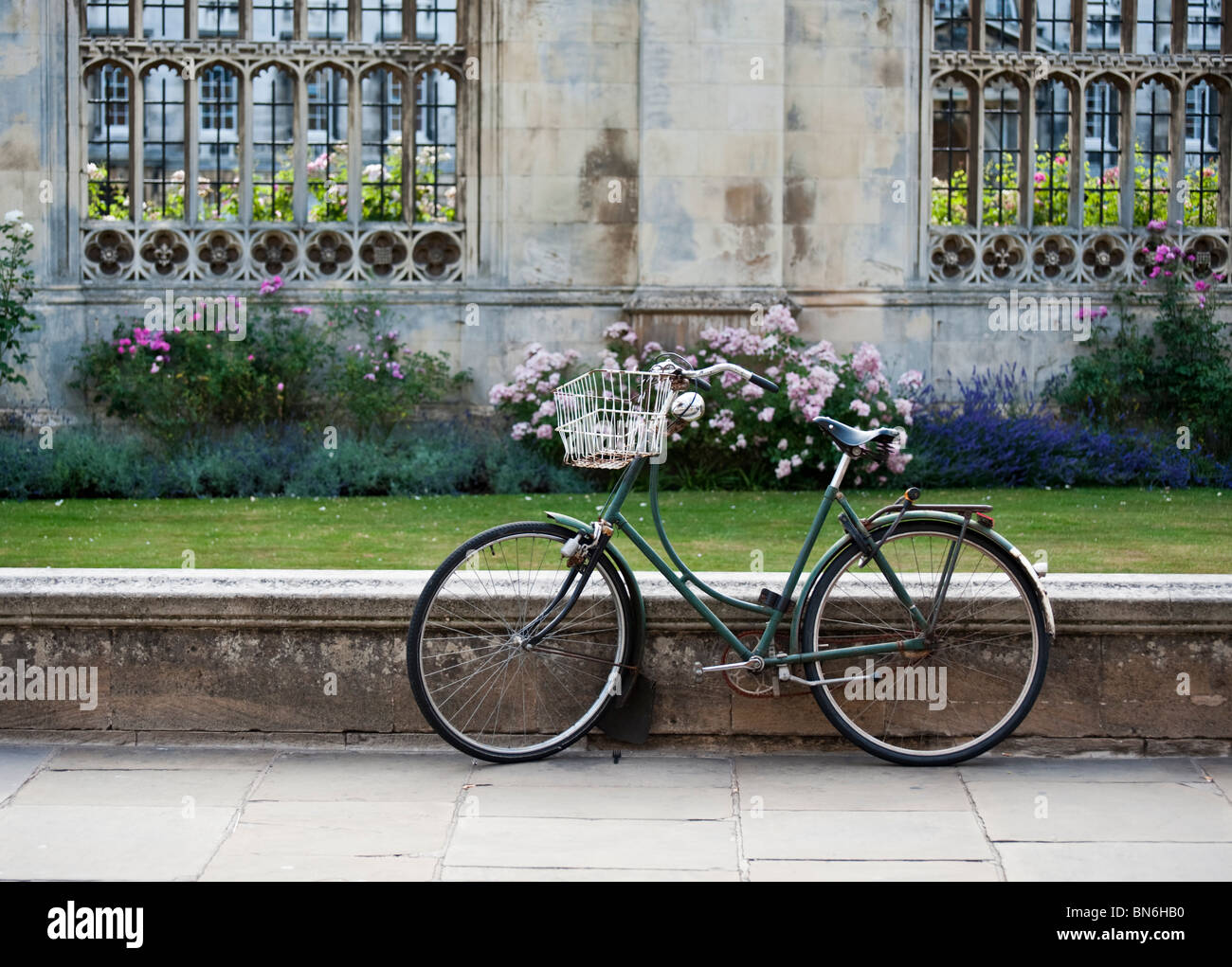Traditional cycle parked against wall outside corpus christi college Cambridge UK Stock Photo
