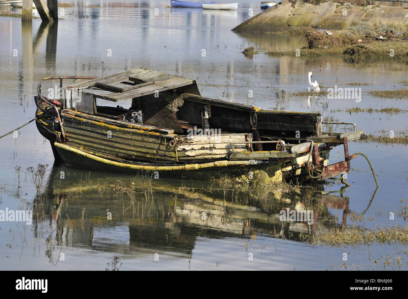 Old derelict wooden day boat reflections Stock Photo - Alamy