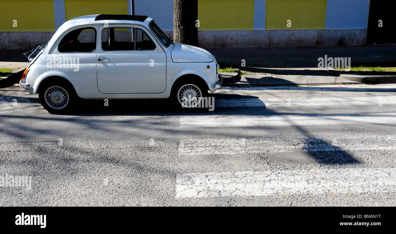 Fiat 500 cinquecento white, parked on pedestrian crossing in Venice Italy, backlit with strong shadows. Stock Photo