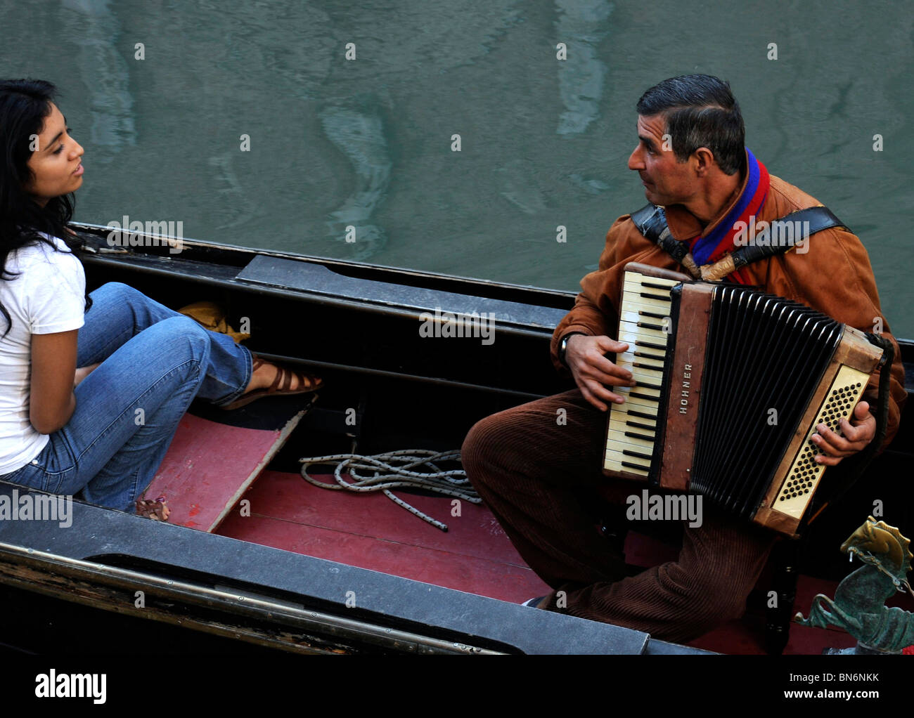 Accordianist serenades young girl on gondola in Venice Italy Stock