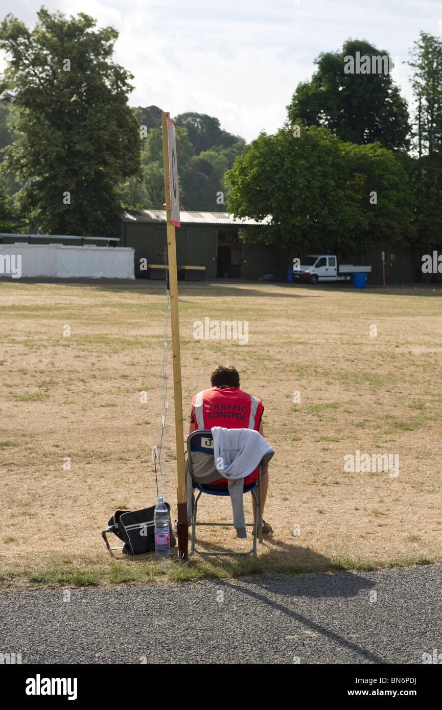 A lonely car parking attendant relaxes at an empty car park early morning at Henley Royal Regatta Stock Photo