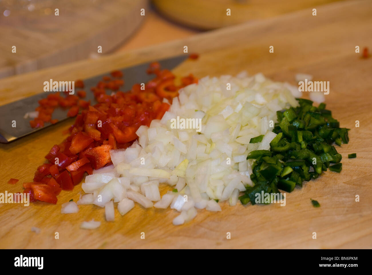 Red peppers, onions and Poblano peppers cut up on cutting board Stock Photo