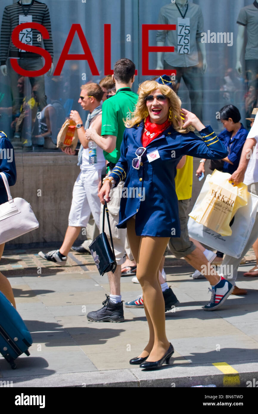 London Gay Pride , young man dressed as air hostesses in short dress ,  female wig , heels & tights get ready for pageant Stock Photo - Alamy