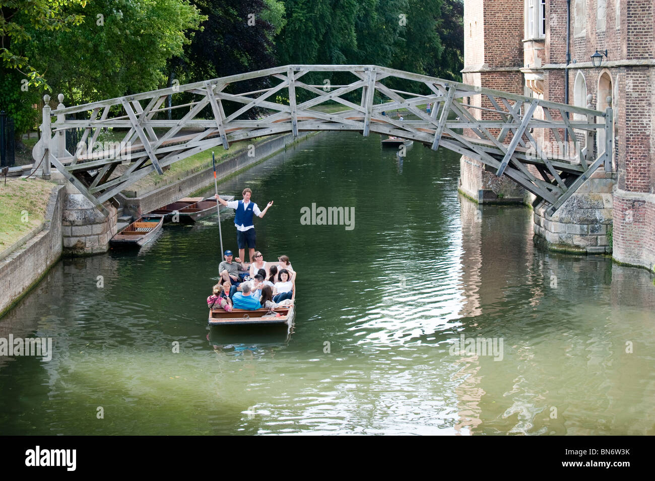 Guided punt tour on the River Cam near the mathematical bridge. Two tourists in punt on sunny summer day. Stock Photo