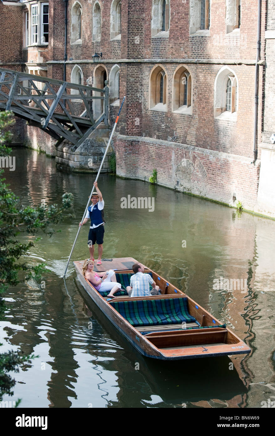 Guided punt tour on the River Cam near the mathematical bridge. Two tourists in punt on sunny summer day. Stock Photo
