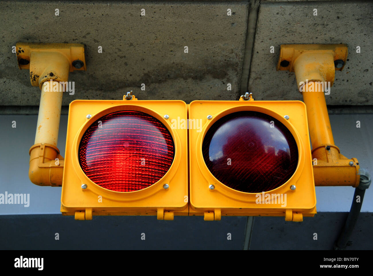 A traffic light at a parking garage is illuminated red, for stop. Stock Photo
