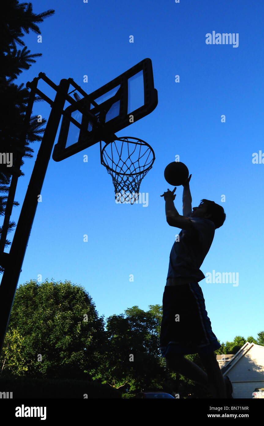 Playing basketball at home in the driveway Stock Photo Alamy