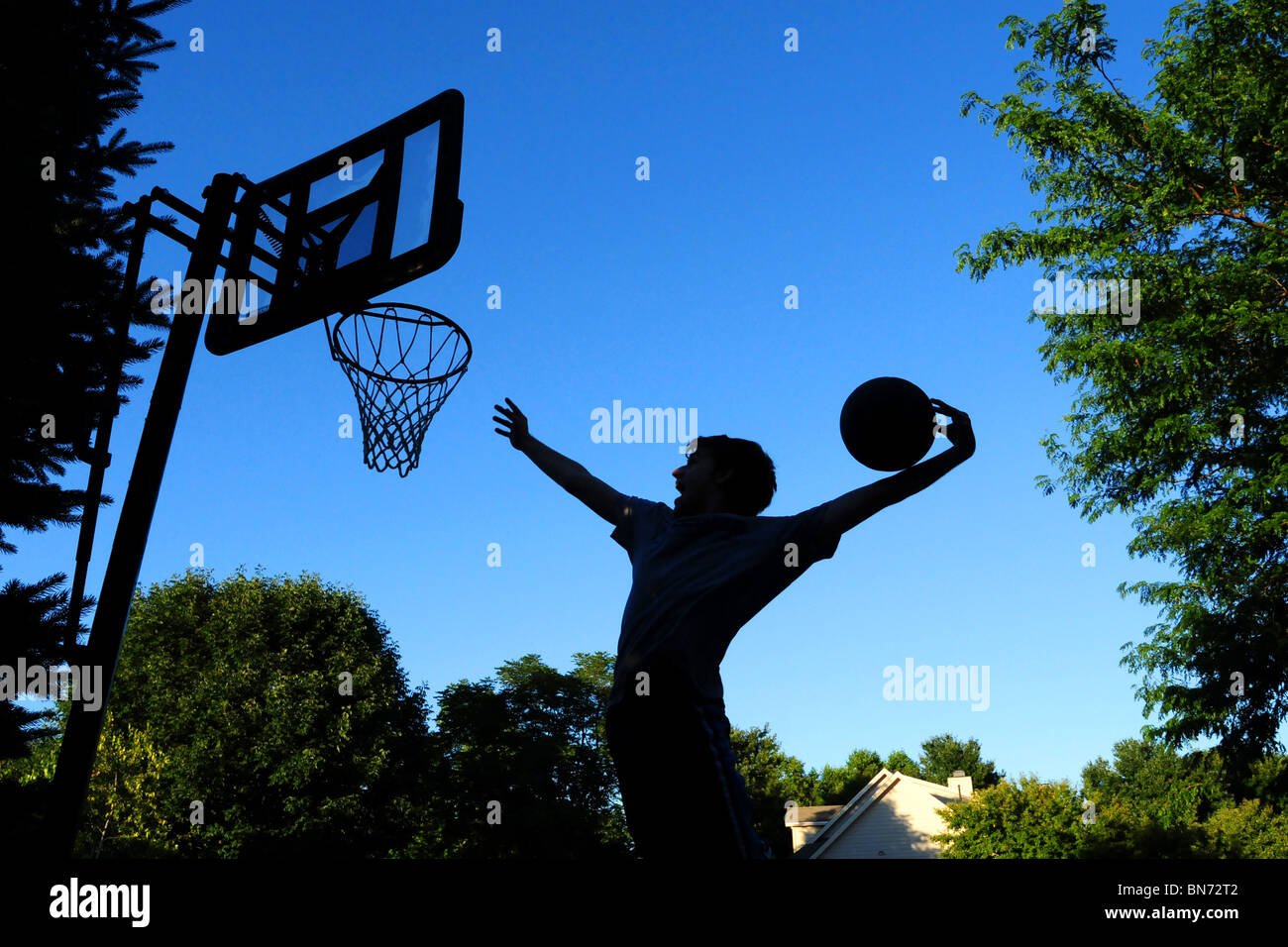 Playing basketball at home in the driveway Stock Photo Alamy