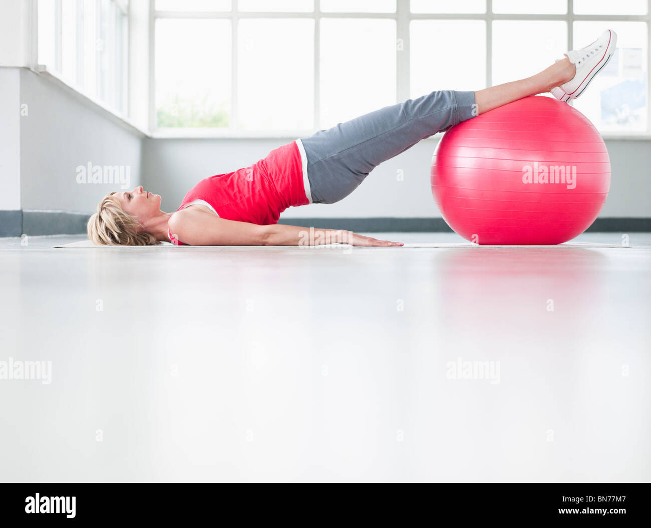 Woman doing leg exercise with gymball Stock Photo
