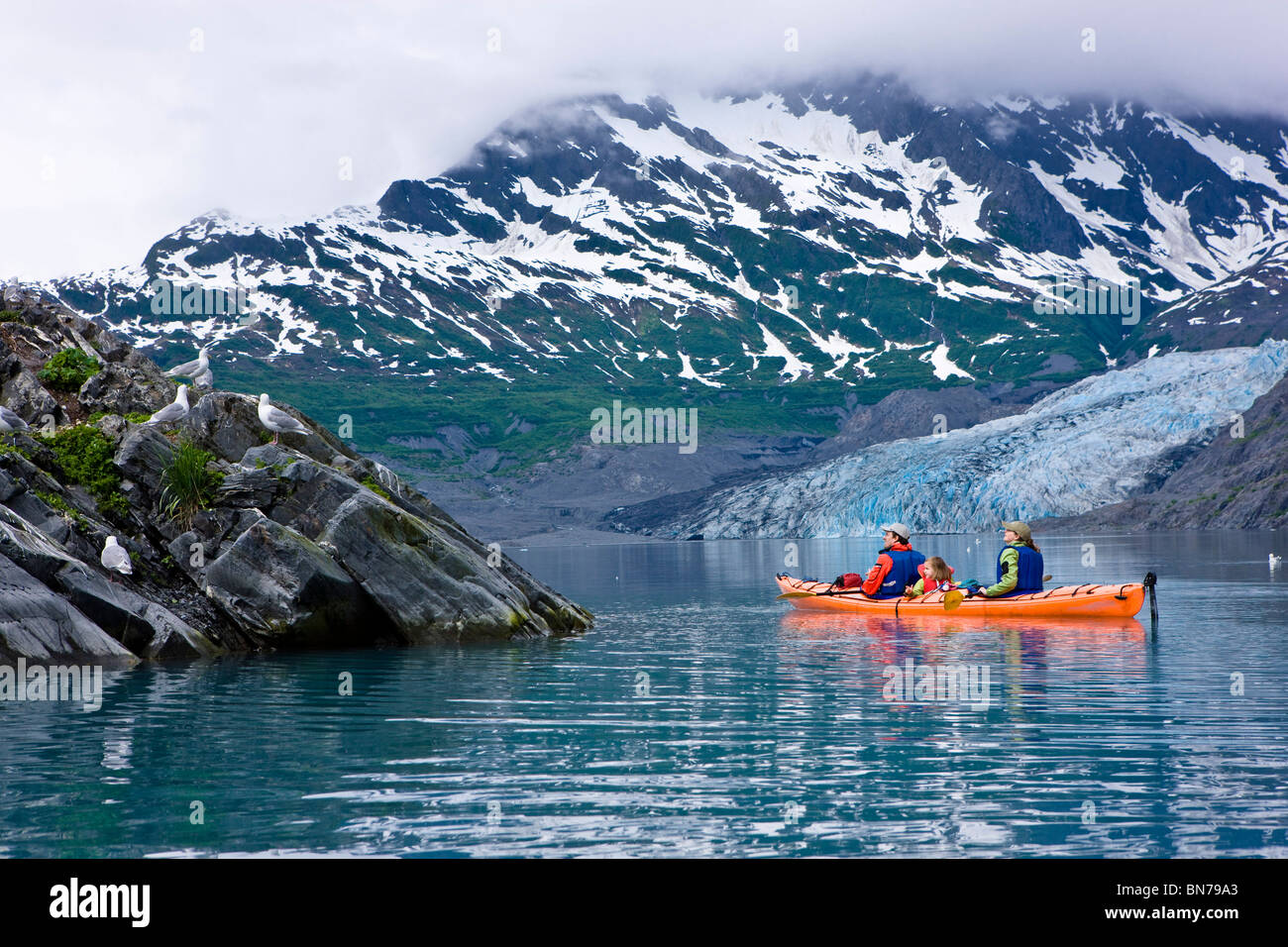 Family kayaking in Shoup Bay with Shoup Glacier in the background, Prince William Sound, Alaska Stock Photo