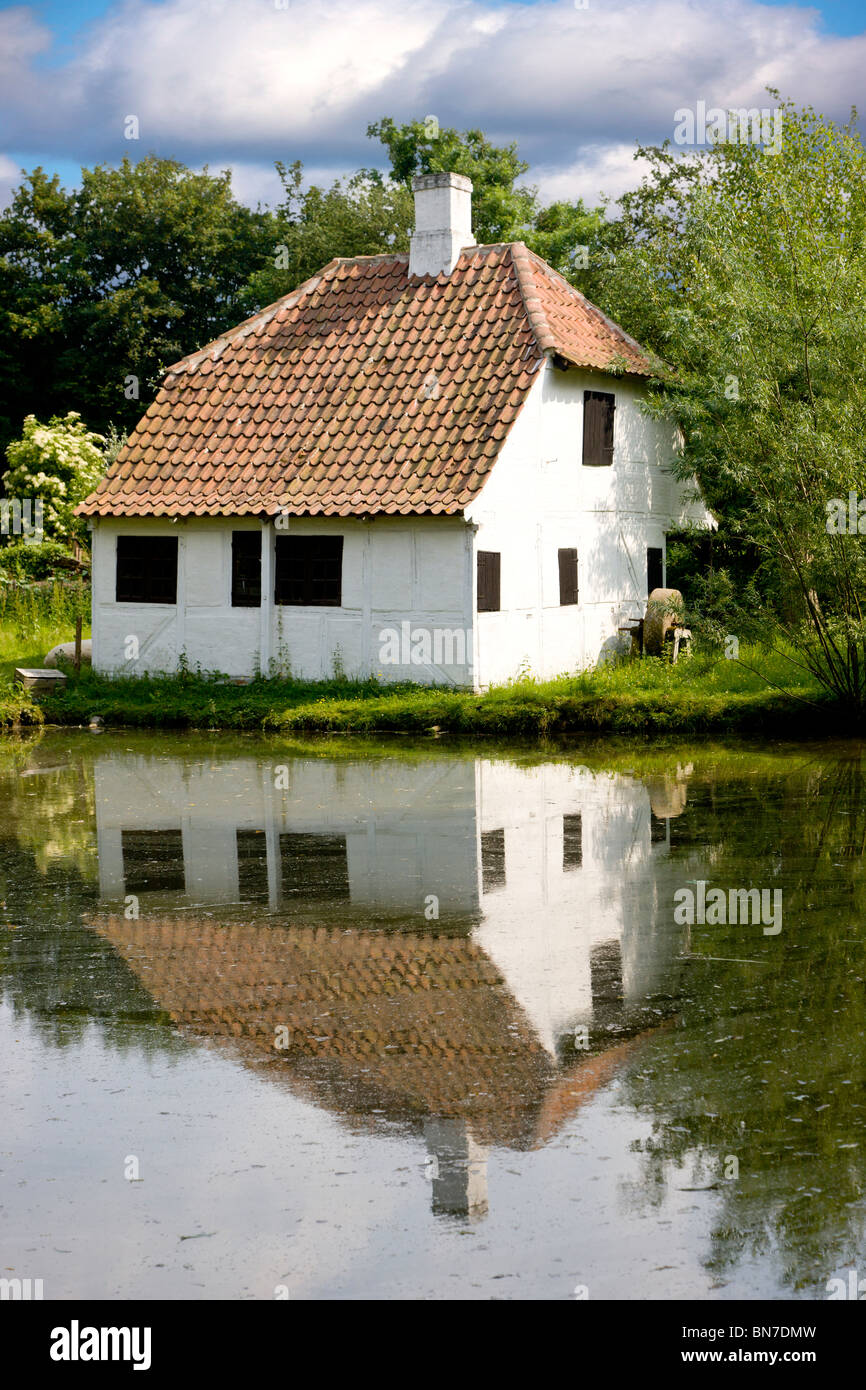 The old blacksmiths little house at the village pond Stock Photo