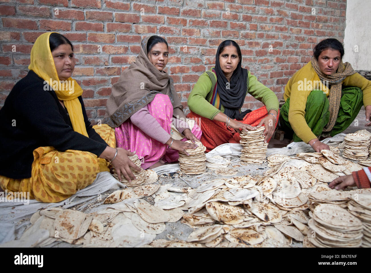 Women picking chapatis for the pilgrims. The Golden Temple. Amritsar. Punjab. India Stock Photo