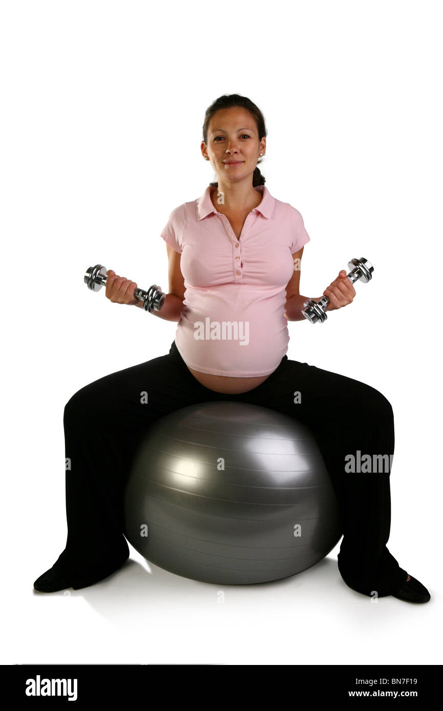 Pregnant girl, woman on grey, silver Swiss exercise ball holding