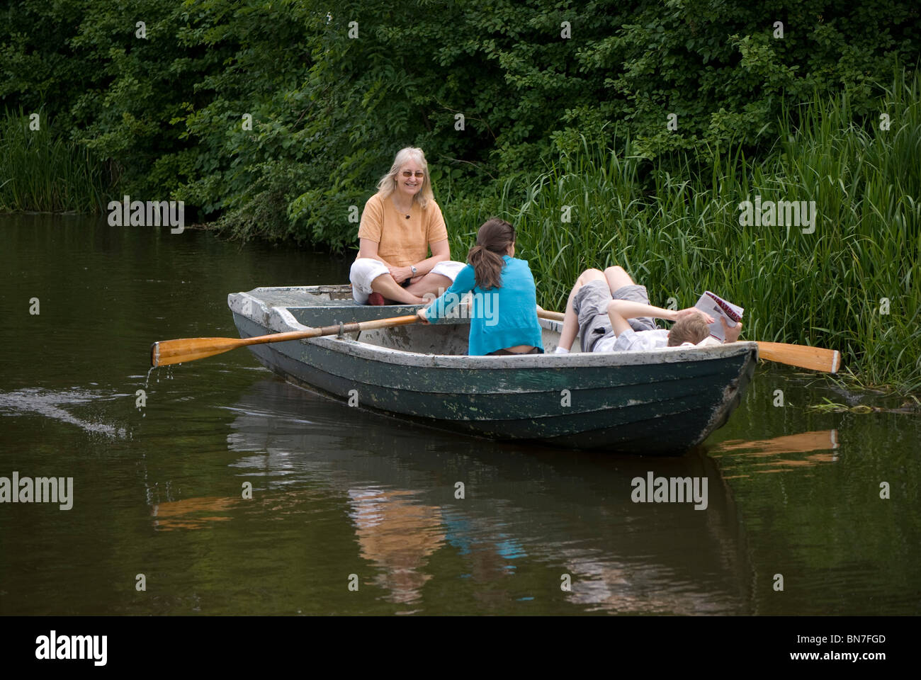 Three people in a rowing boat on the Union Canal, Edinburgh, Scotland ...