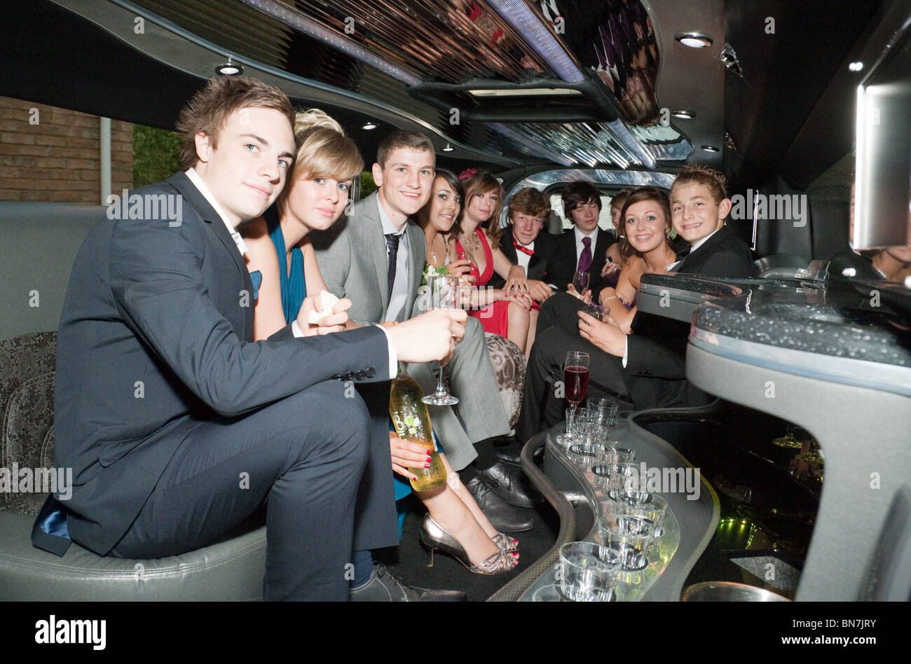 Teenage girls and boys pose inside their stretch limo all dressed up, going to their high school prom, Cambridgeshire UK Stock Photo