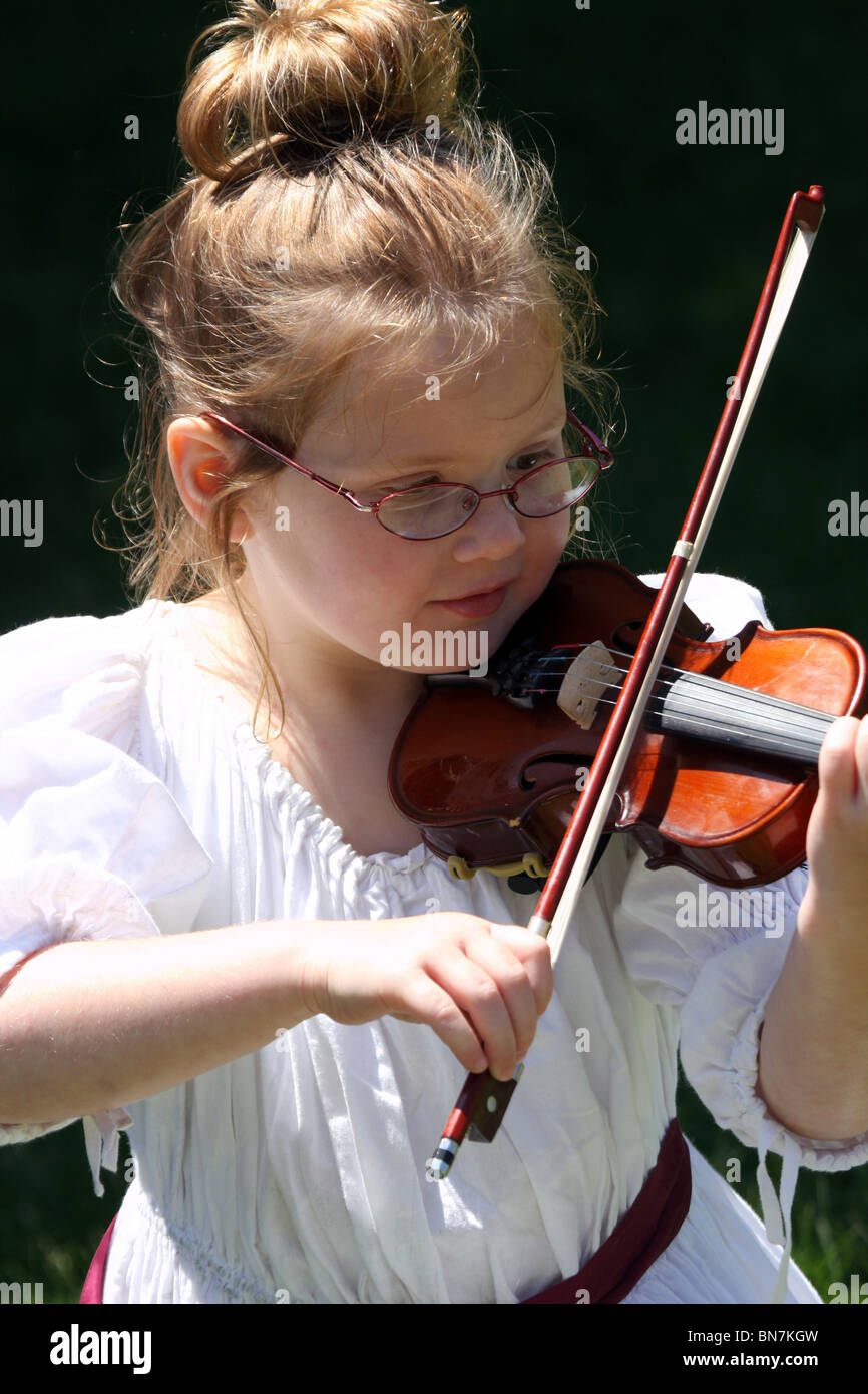 A young white girl in a white dress playing the violin Stock Photo - Alamy