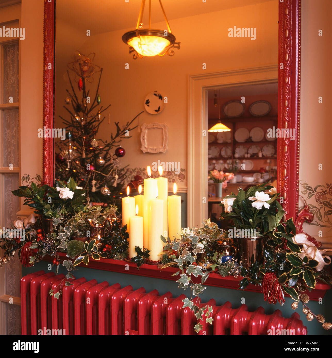 Close Up Of Candles And Christmas Foliage Decoration On Shelf In
