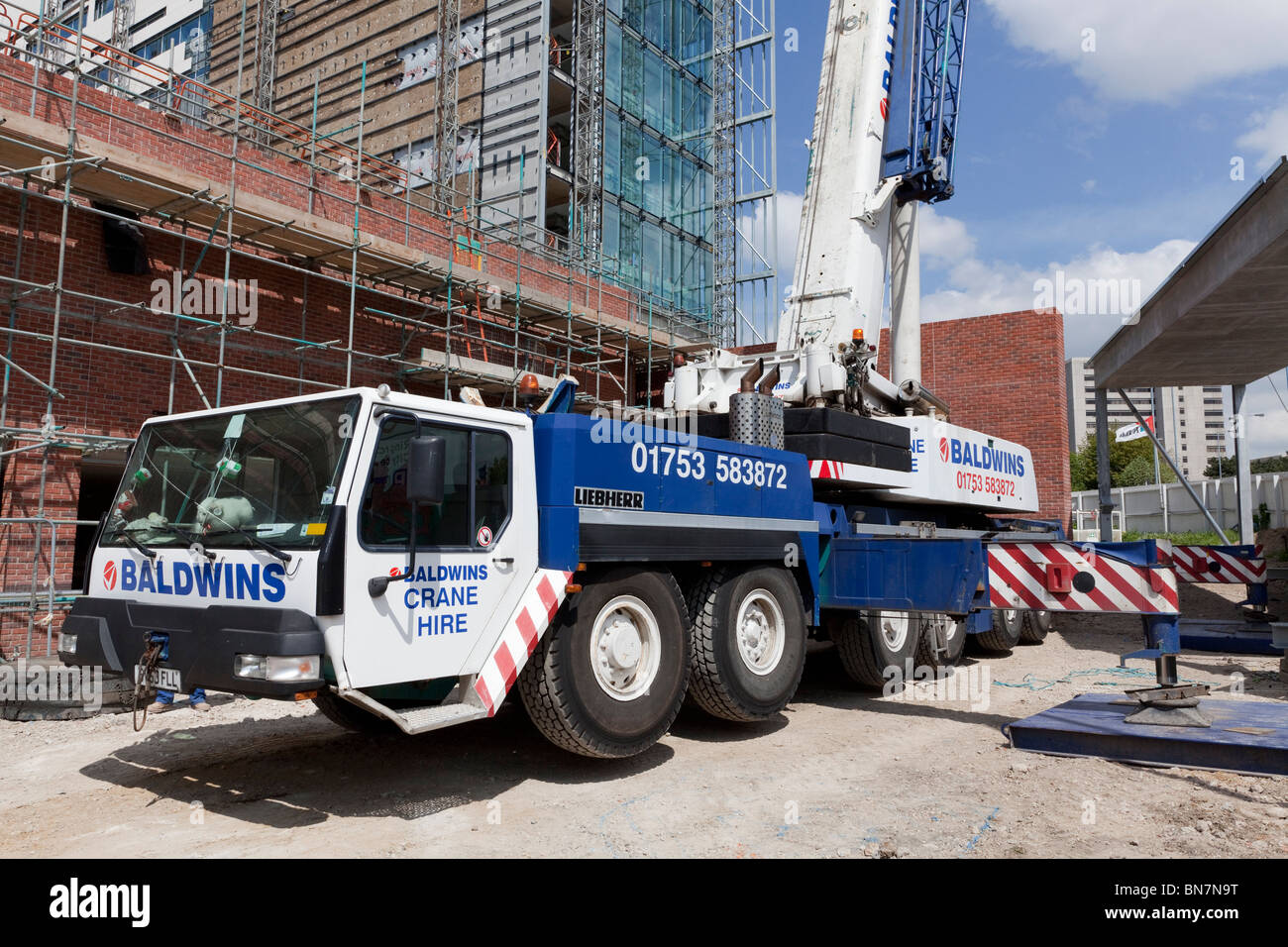 Setting up outriggers for a tall mobile crane on a construction site
