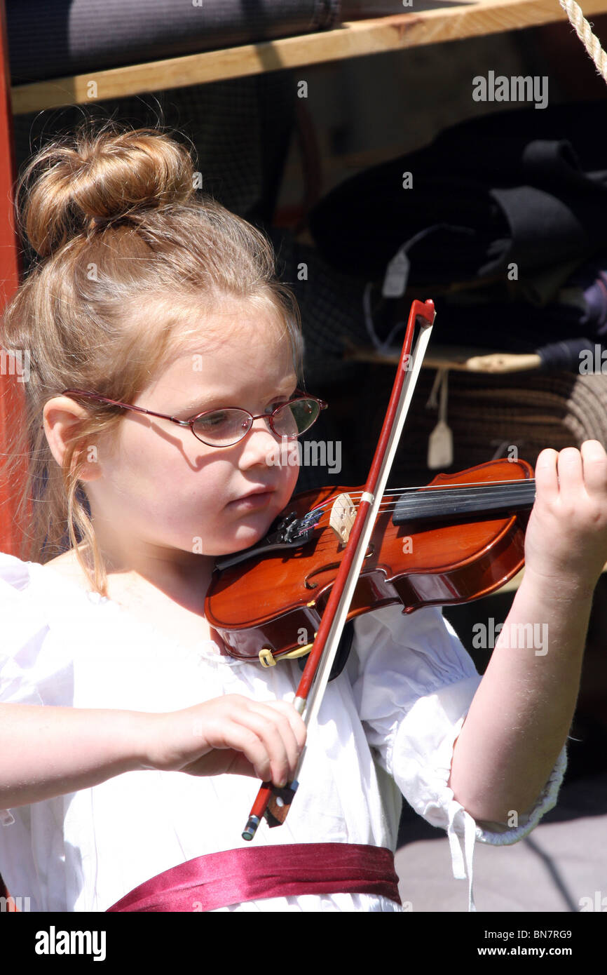 A young accomplished girl in a white dress playing the violin Stock ...