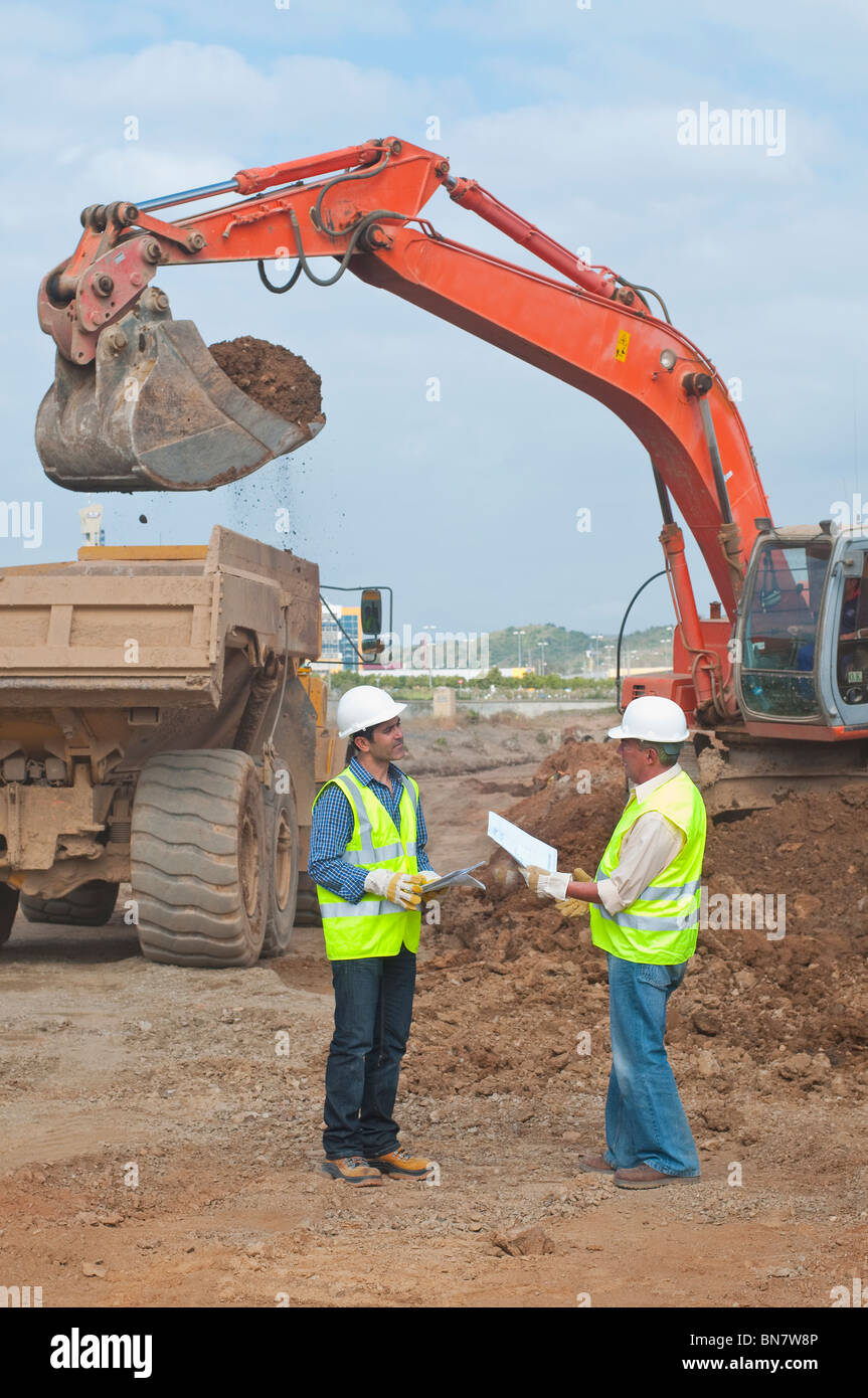 Hispanic construction workers talking on construction site Stock Photo