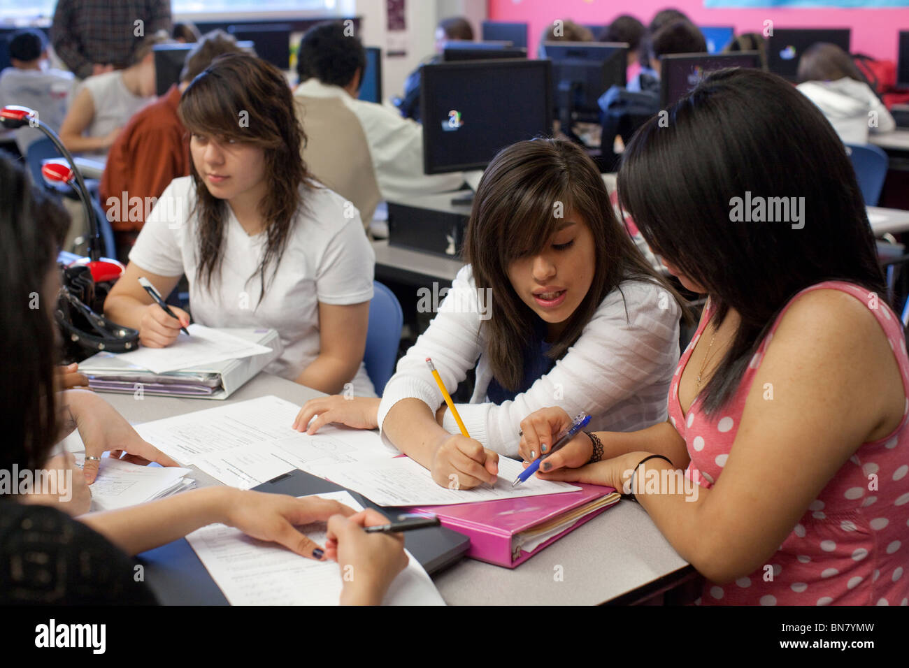 Hispanic high school girls work together on assignment in English class Stock Photo