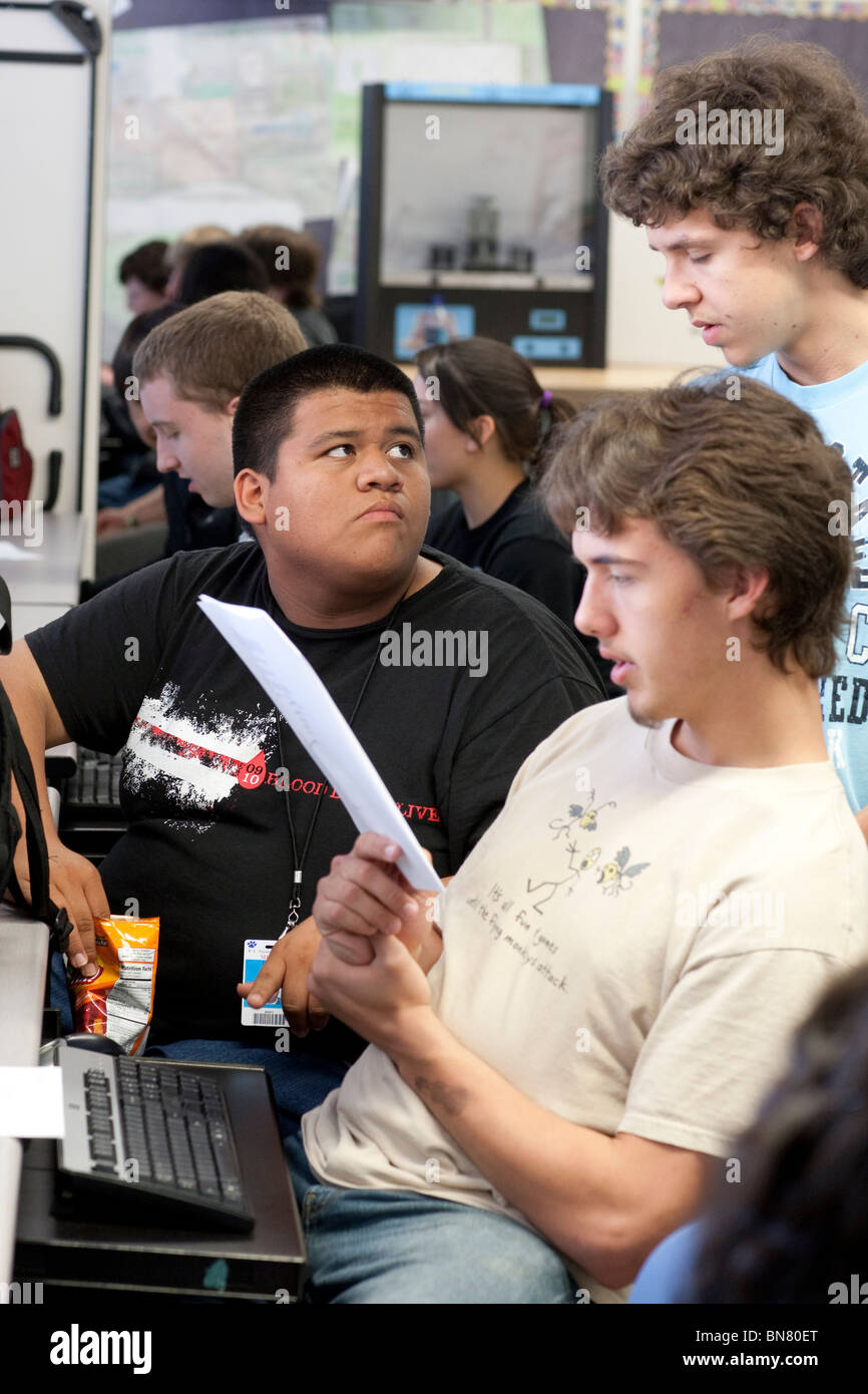 High school boys look at instructions together during class. Stock Photo