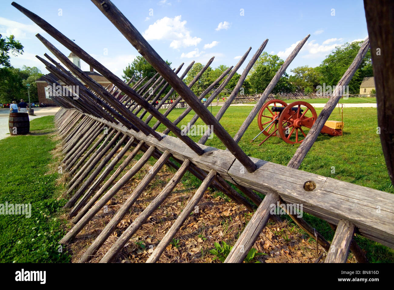 Wooden spike fences and cannon are among military defenses of the 18th Century than can be seen at historic Colonial Williamsburg in Virginia, USA. Stock Photo