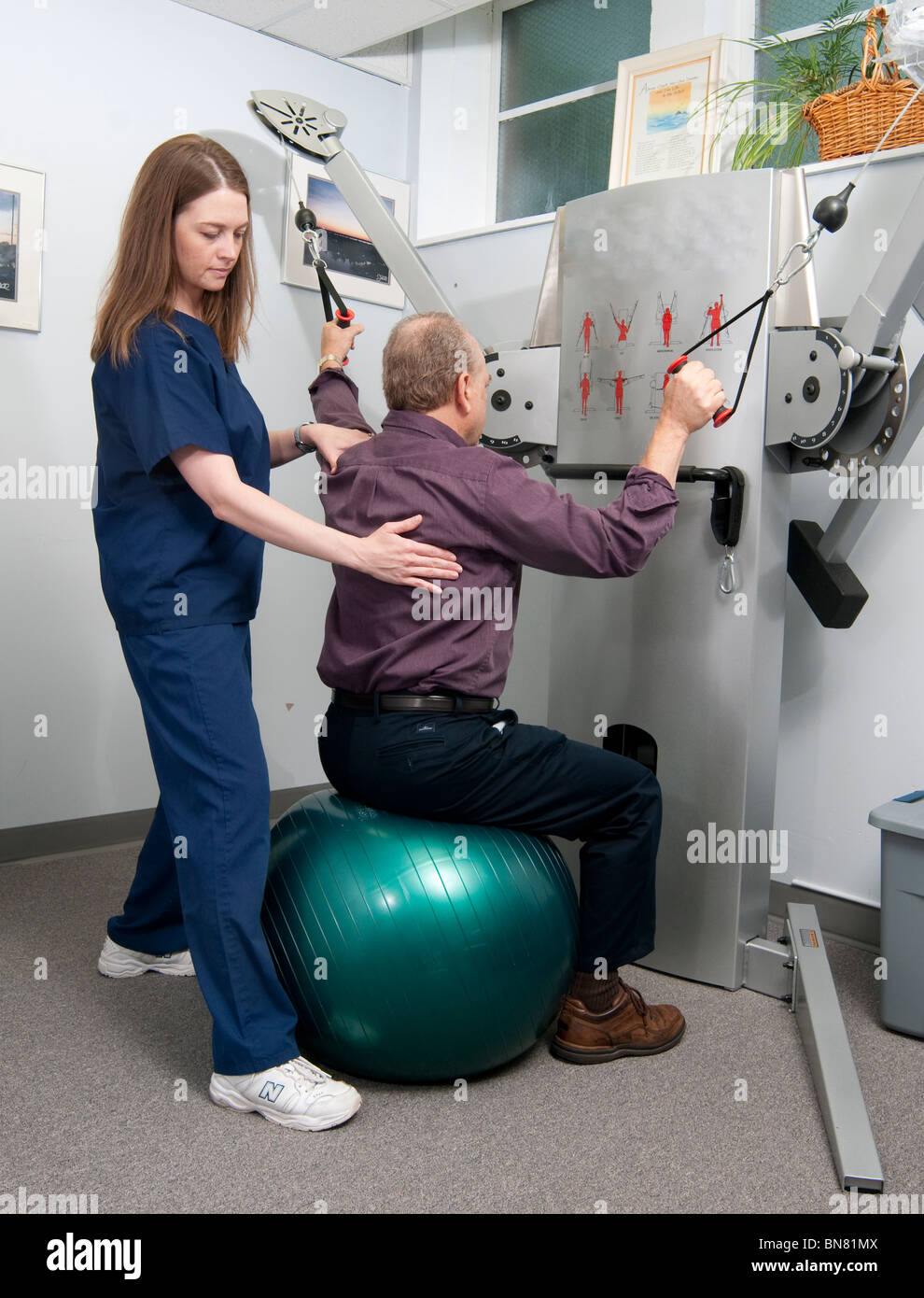 Physical therapist working with an older man on his lower trapezius muscle Stock Photo
