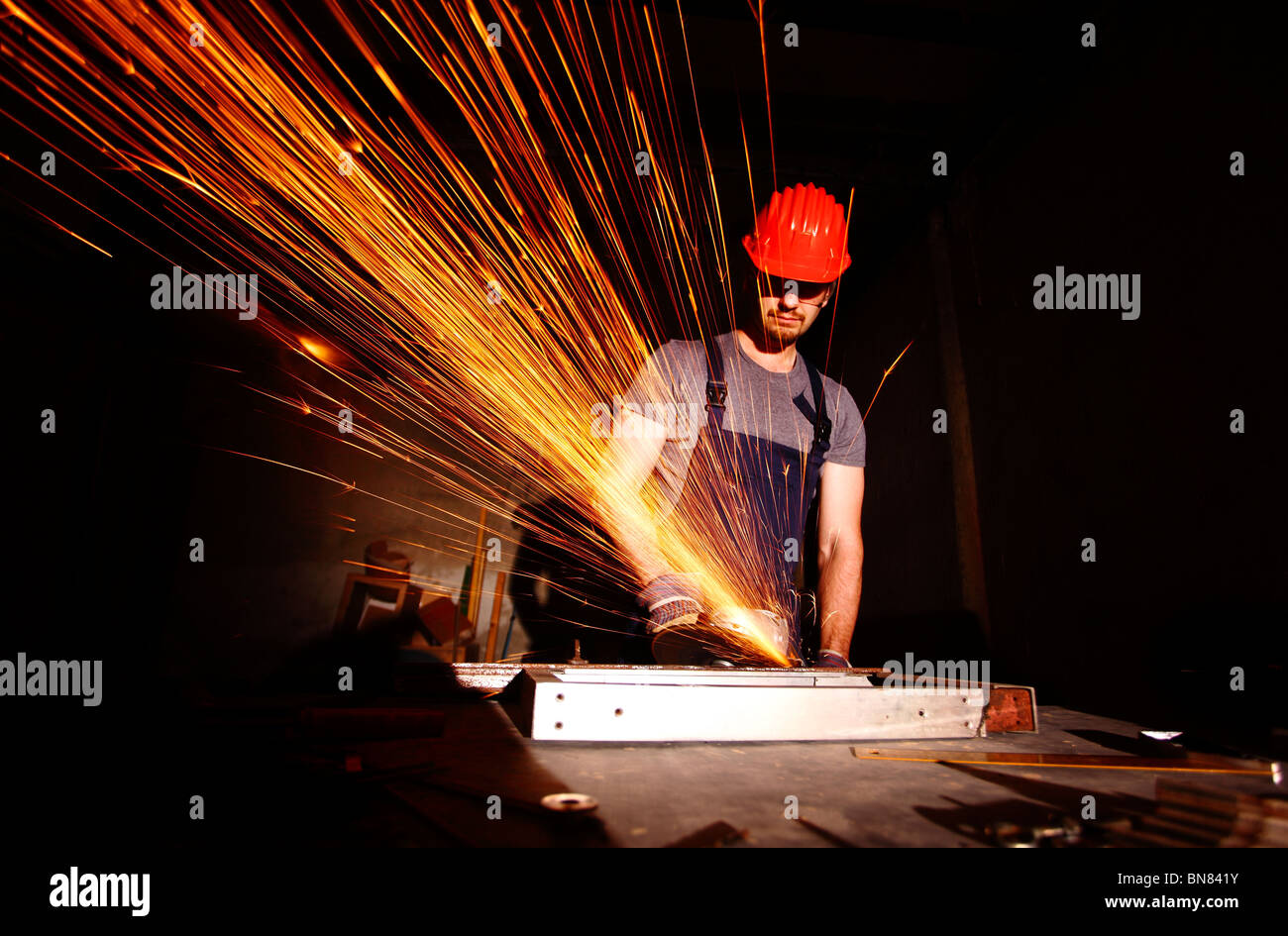 manual worker cut metal with electric grinder Stock Photo