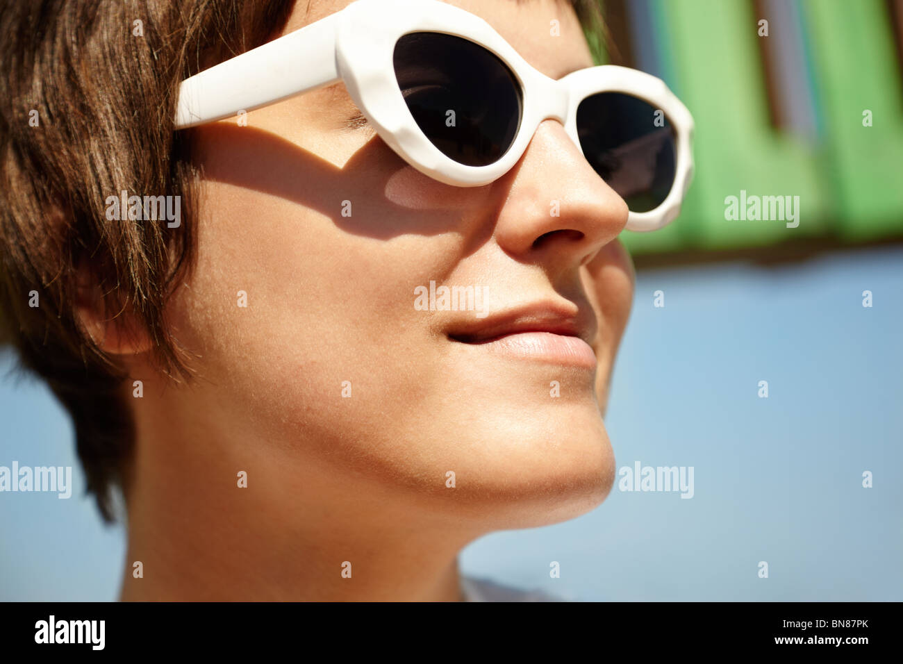 Young Woman Wearing Sunglasses, selective focus on nearest part Stock Photo