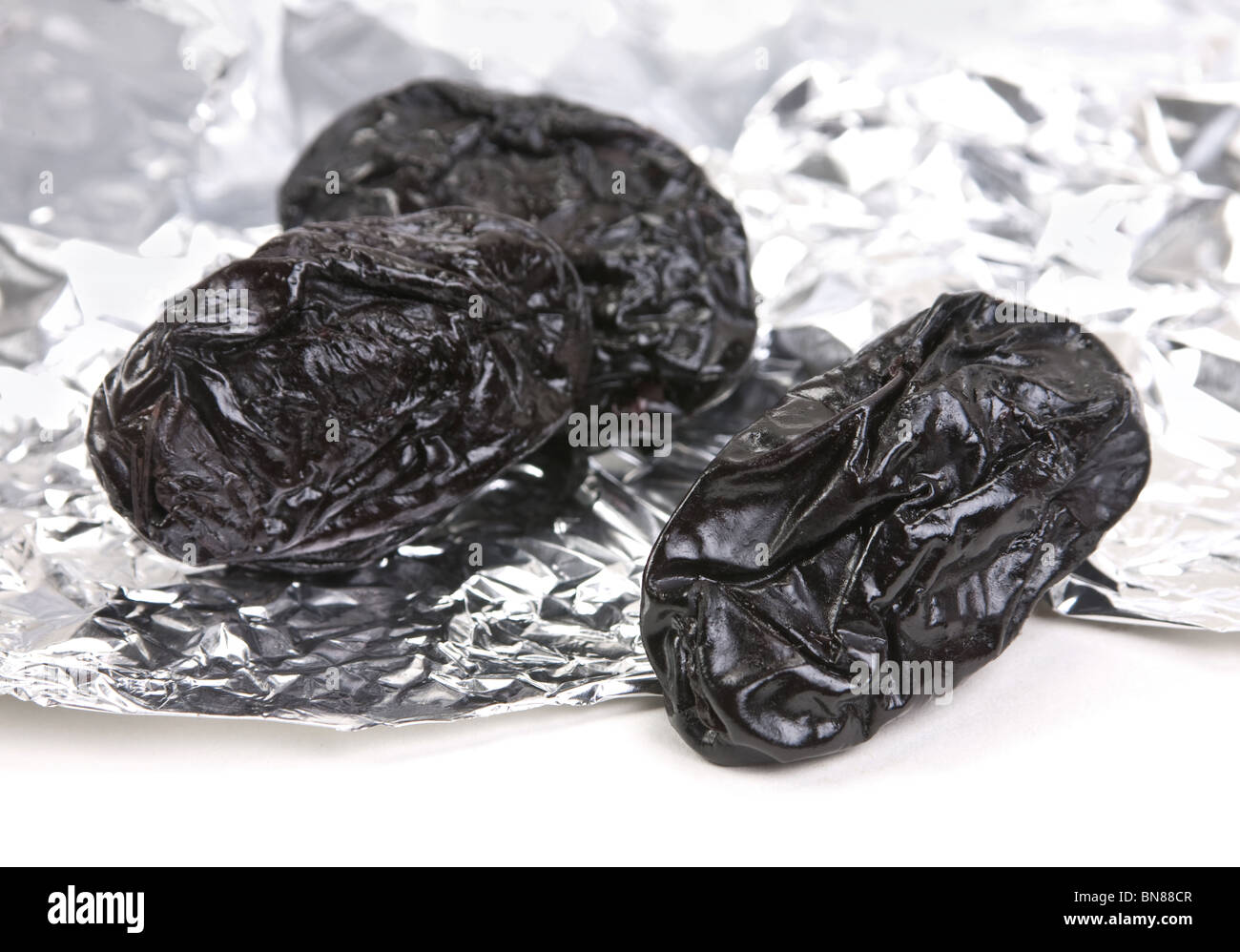 Dried fruit prune closeup on foil background Stock Photo