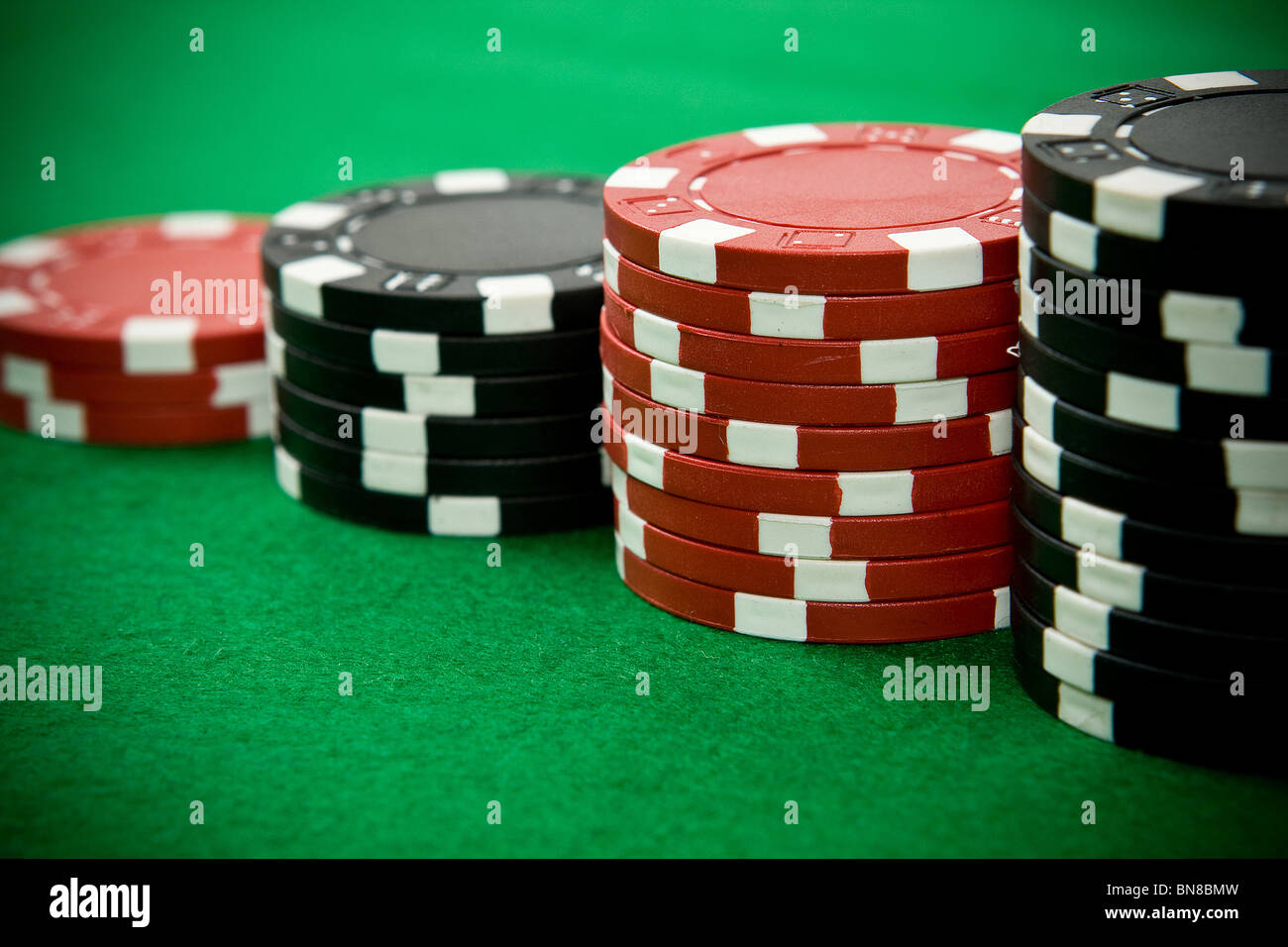 Stack of black and red poker chips on green table Stock Photo - Alamy