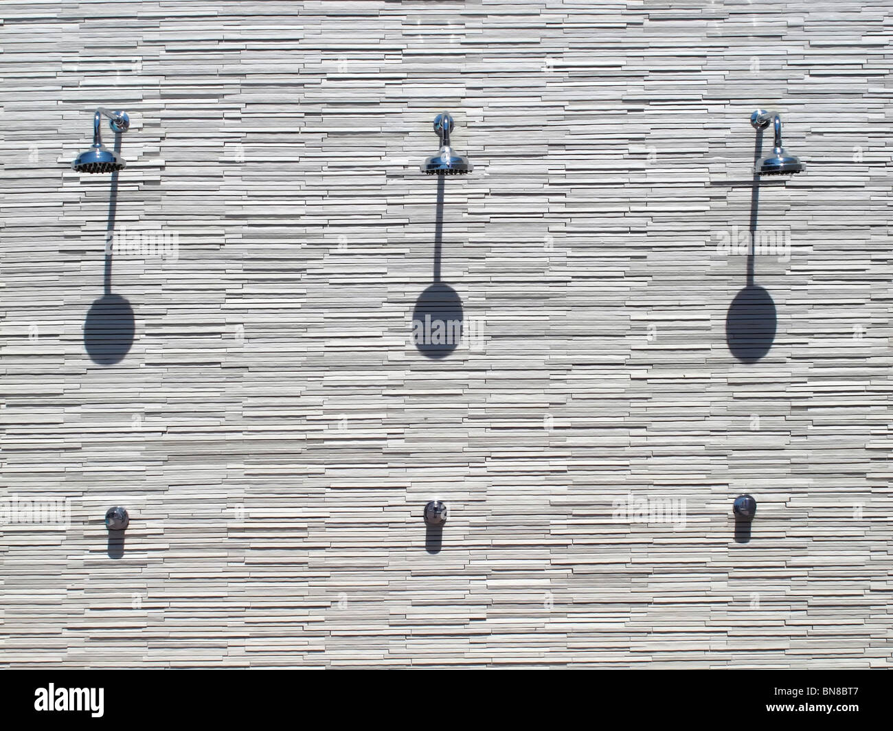 shower heads at the white wall of resort hotel Stock Photo Alamy