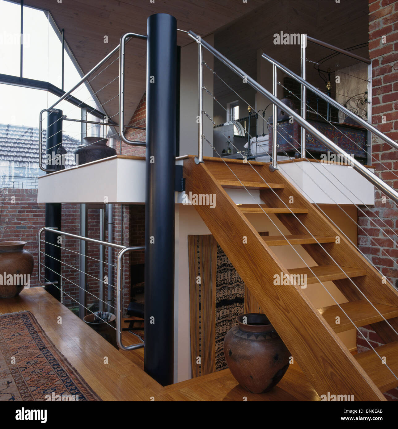 Open Tread Wooden Staircase To Mezzanine Floor In Large Open Plan