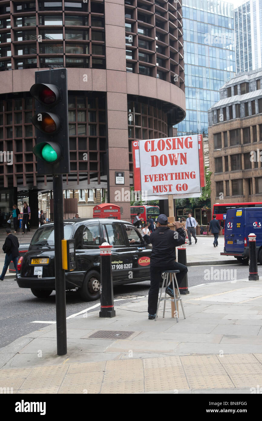 Man holding closing down placard in the City of London GB UK Stock Photo