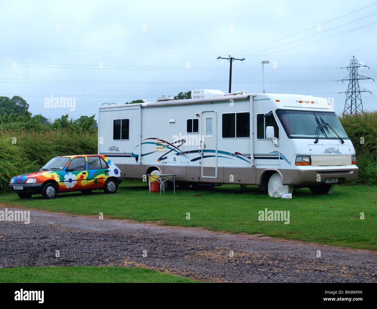 Large American style motorhome with colourful car, Devon, UK Stock