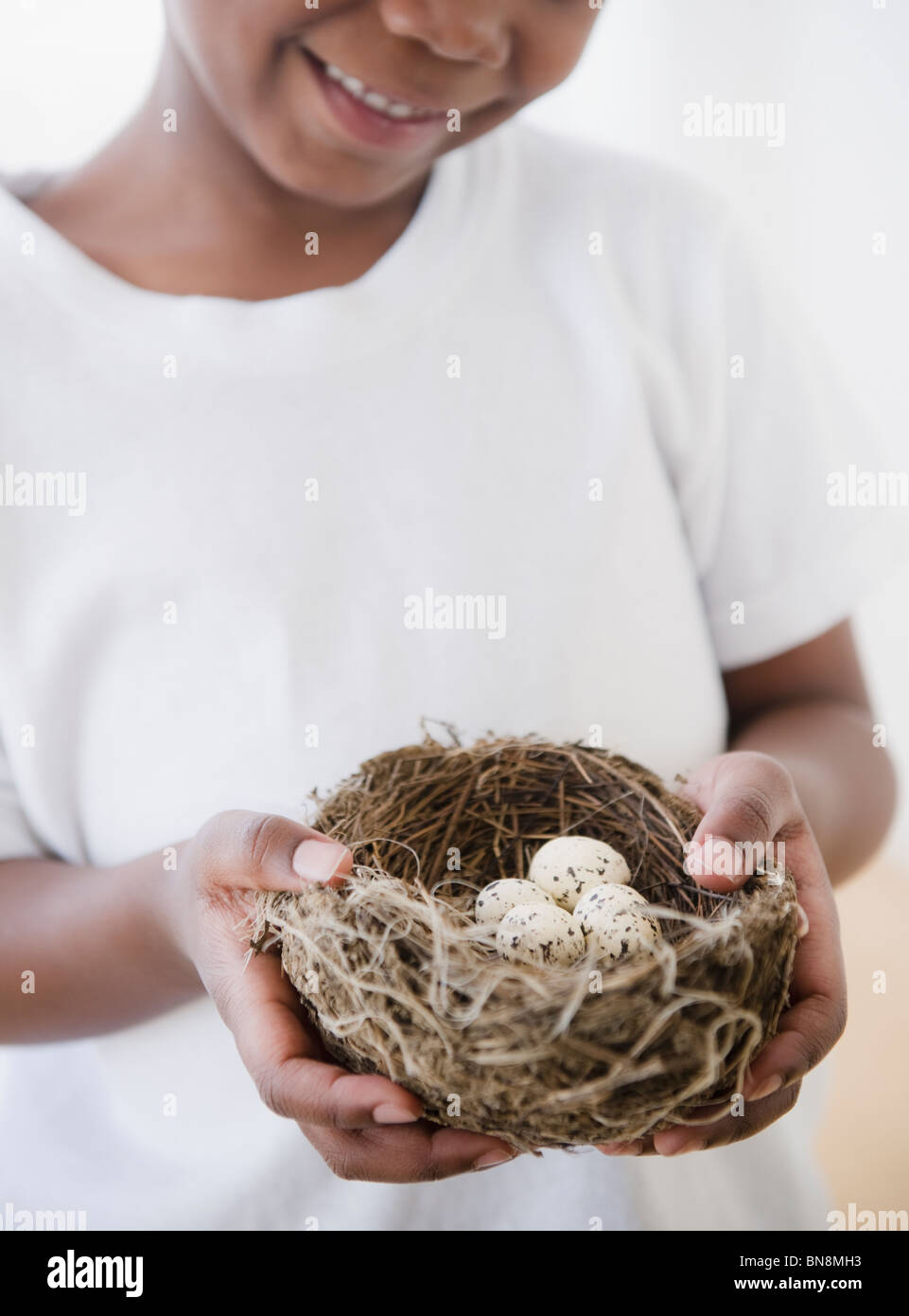 Black boy holding nest with bird's eggs Stock Photo
