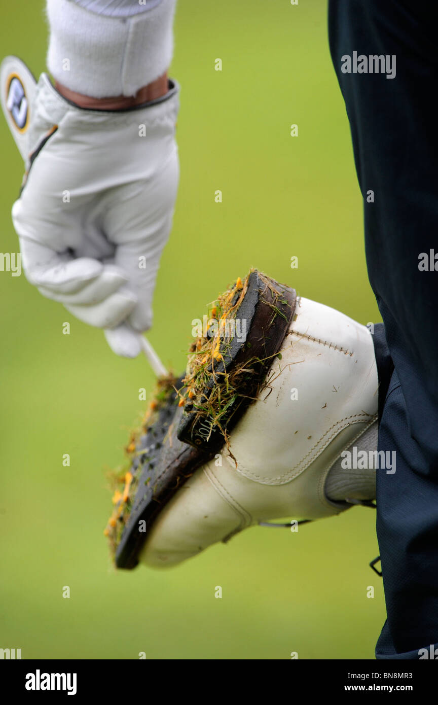 A golfer uses a tee to clean wet grass from his spikes at the Celtic Manor Wales Open 2008 May 2008 Stock Photo