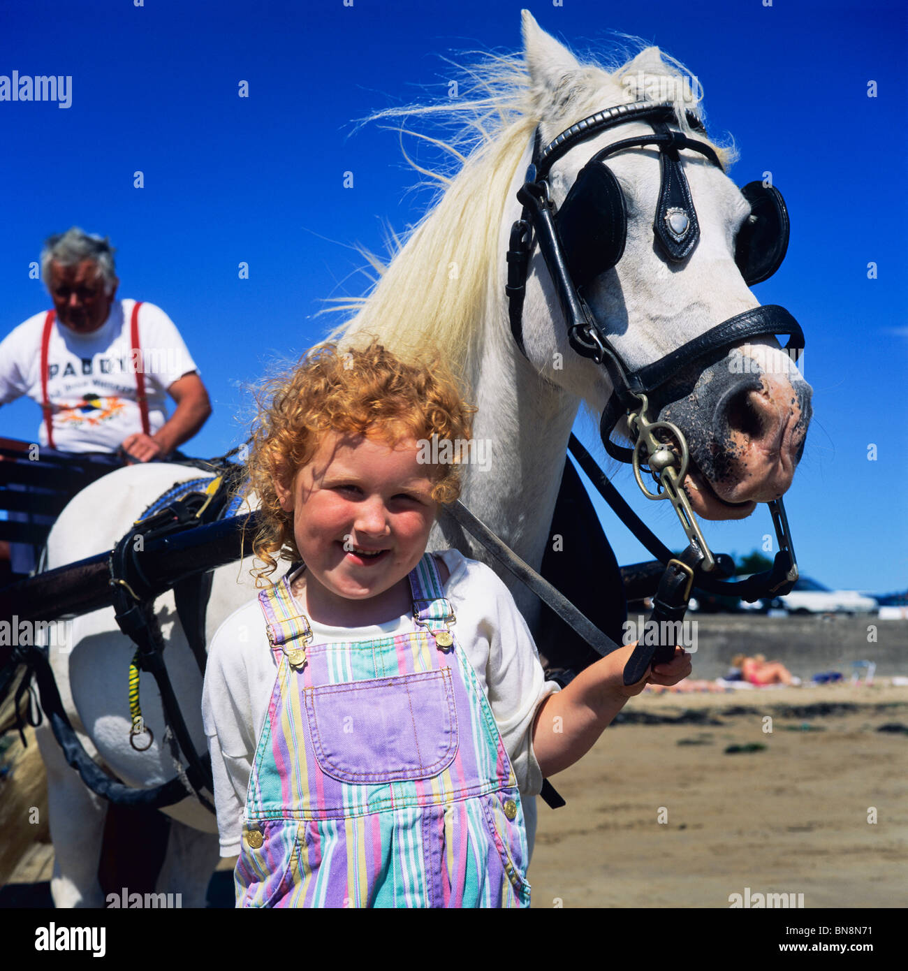 RED HAIRED LITTLE GIRL & WHITE HORSE IRELAND Stock Photo