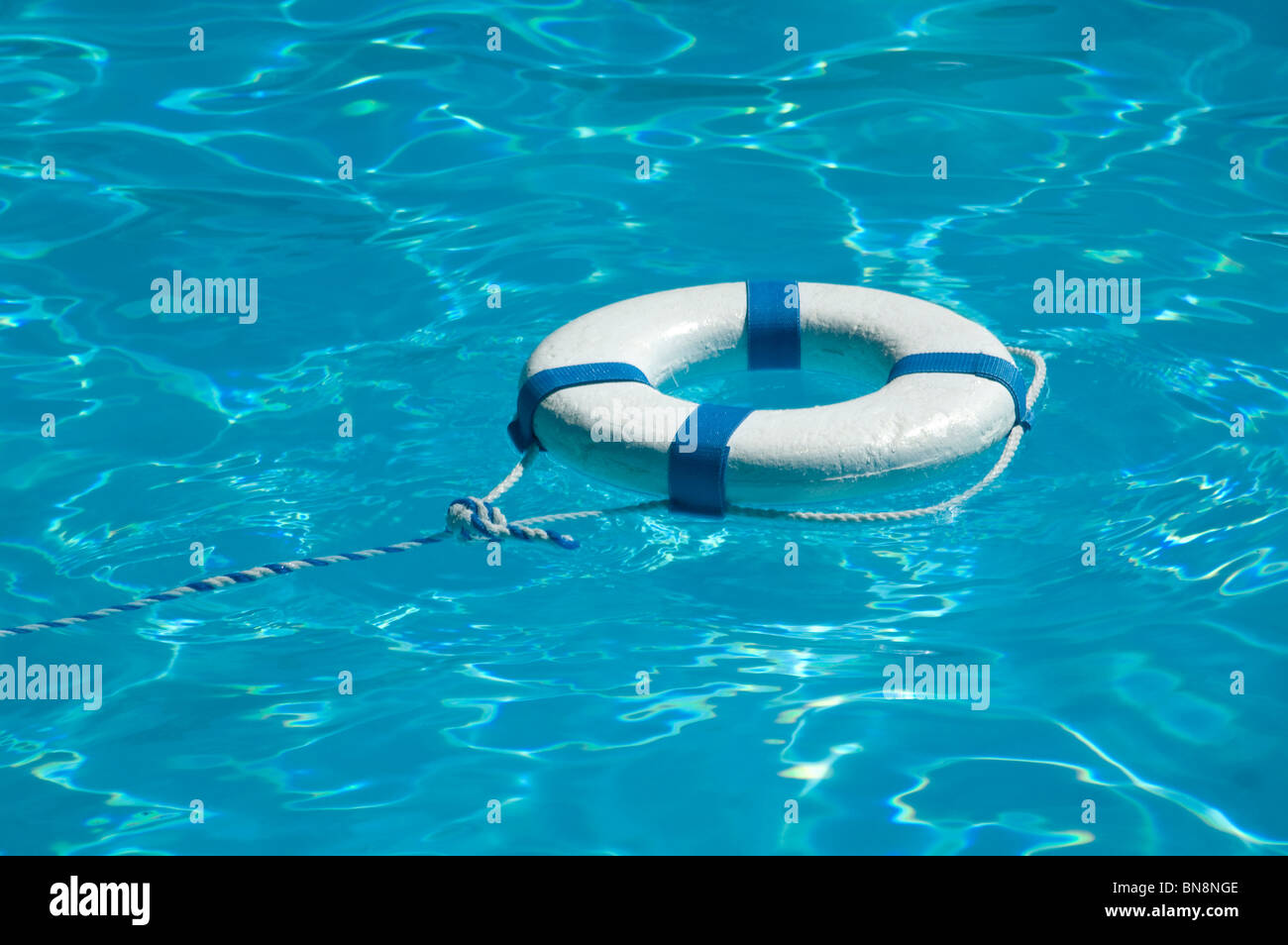 Life ring floating on top of sunny blue water Stock Photo