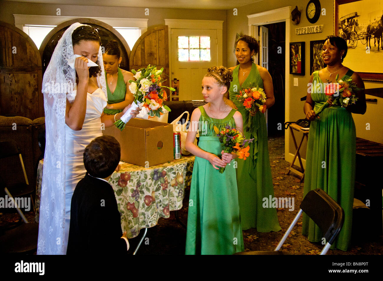 A young mixed-race bride has a weepy moment with her bridesmaids before a formal wedding in Orange, CA. Stock Photo
