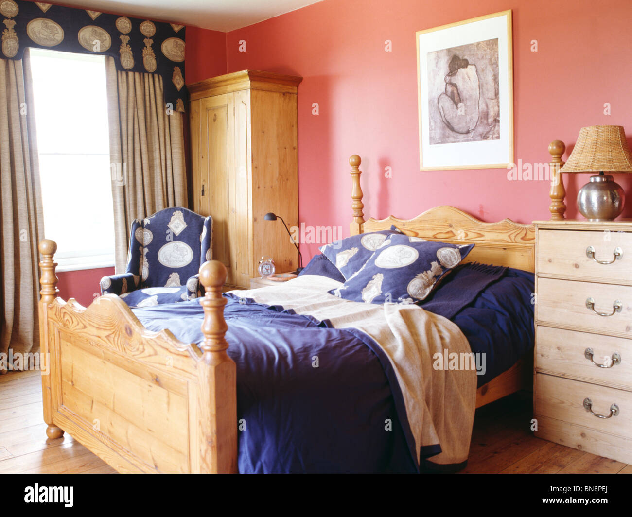 Pine Bed With Blue Cushions And Bedlinen In Pink Bedroom With Pine