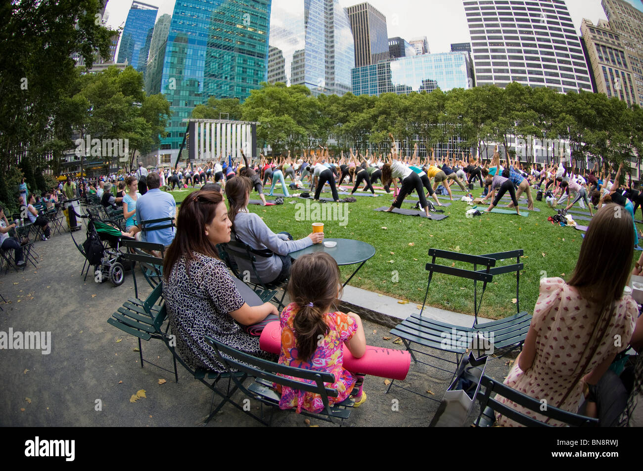 Hundreds of yoga practitioners of all levels participate in a free yoga class given in Bryant Park in New York Stock Photo