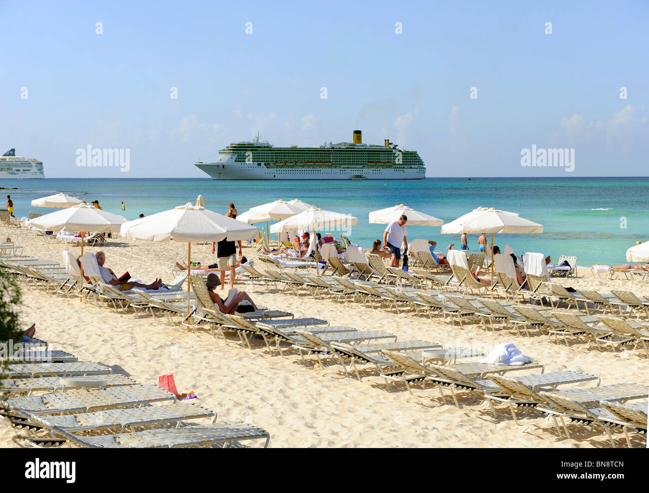 Beach chairs line shore at beaches Grand Cayman Islands Caribbean Stock