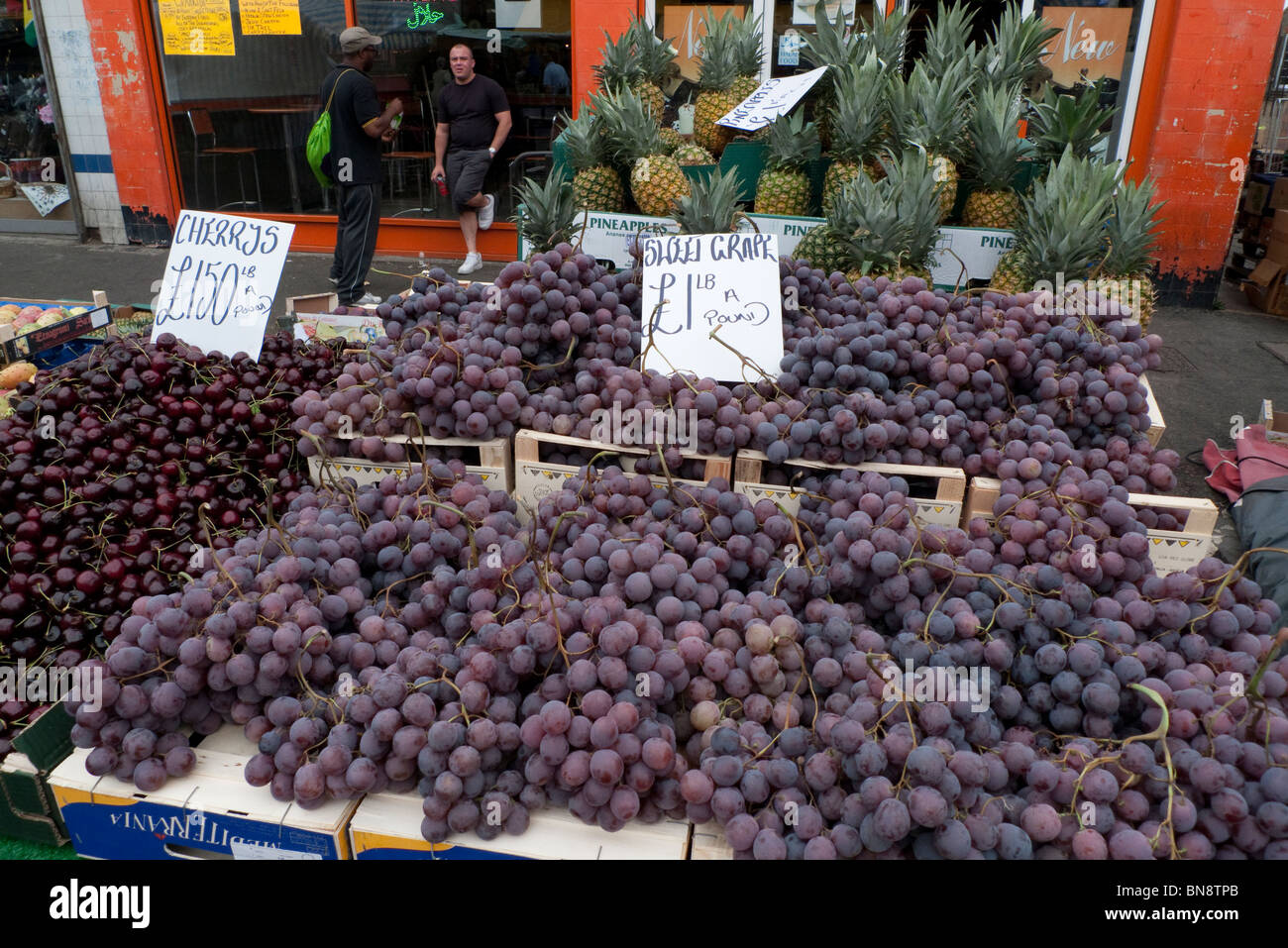 Grapes for sale on an outdoor street market stall at Ridley Road Market, Dalston, East End, London England UK KATHY DEWITT Stock Photo