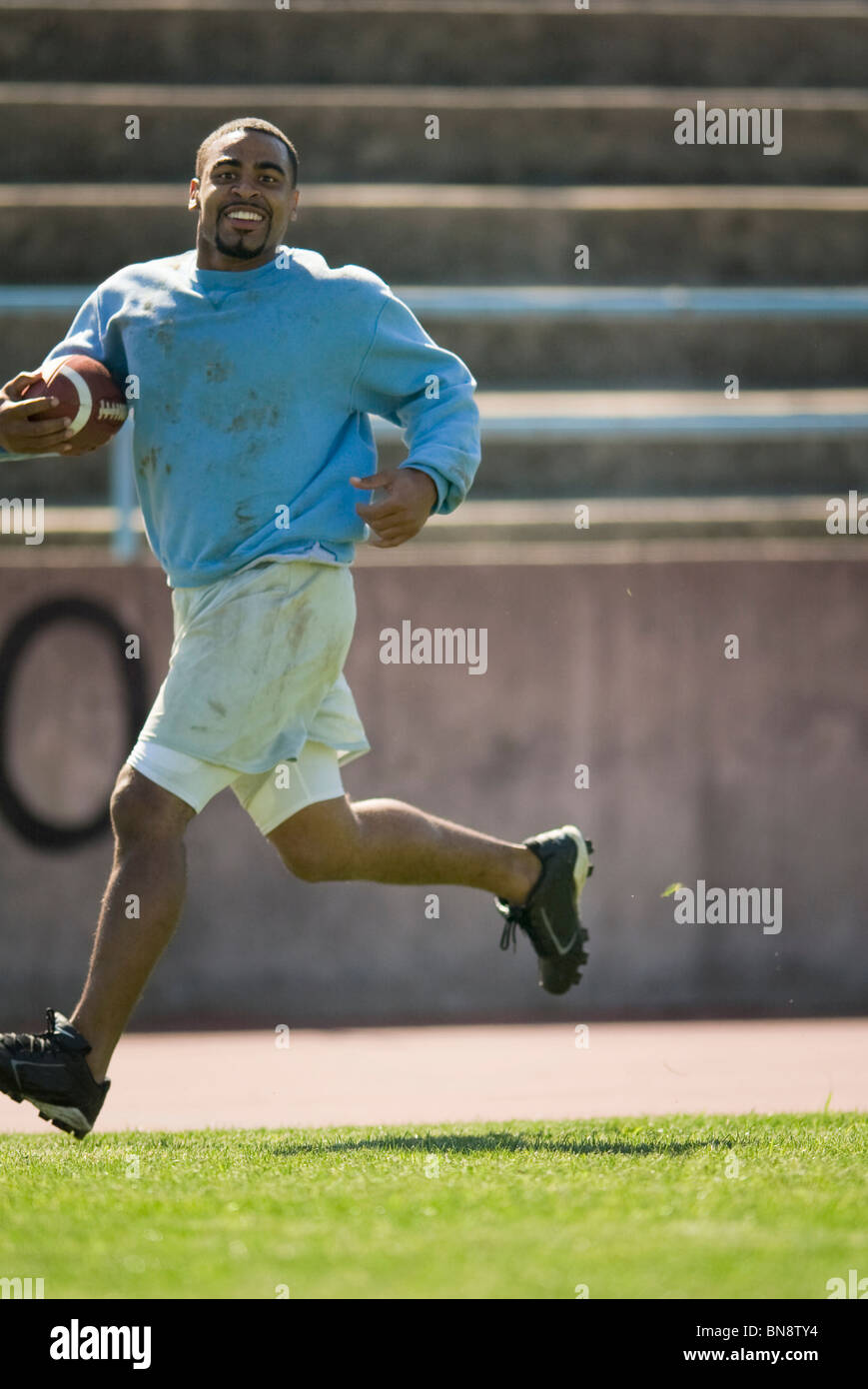 Man running with football Stock Photo