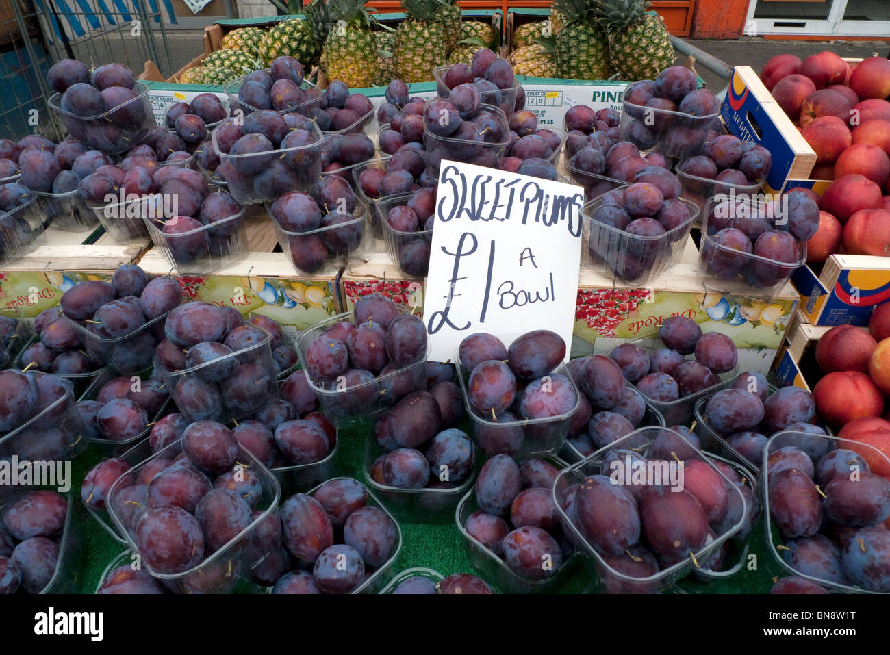 Plums for sale on an outdoor street market stall at Ridley Road Market, Dalston, East End, London England UK KATHY DEWITT Stock Photo