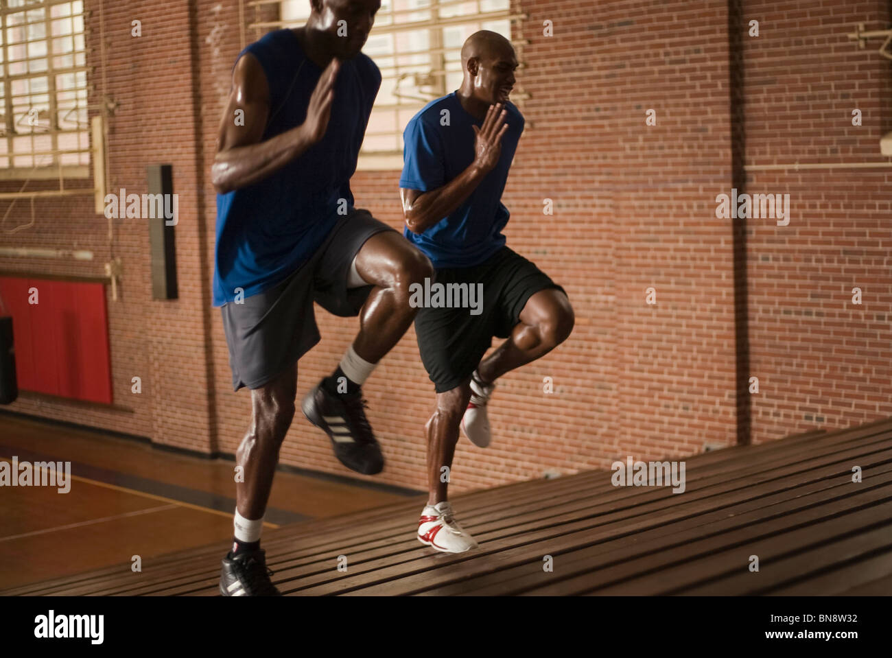 Basketball players running on bleachers Stock Photo