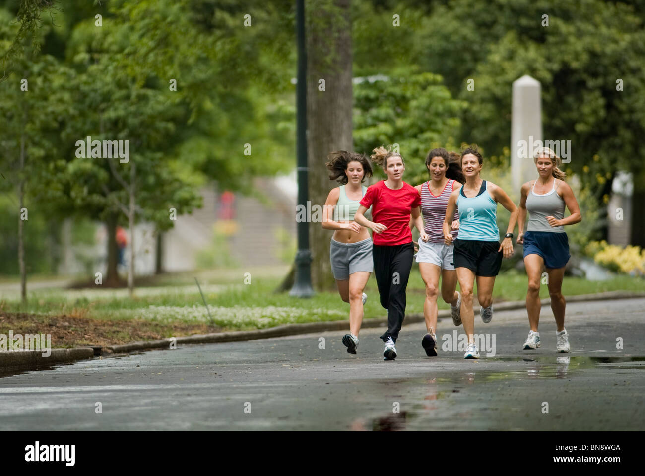 Runners jogging in park Stock Photo