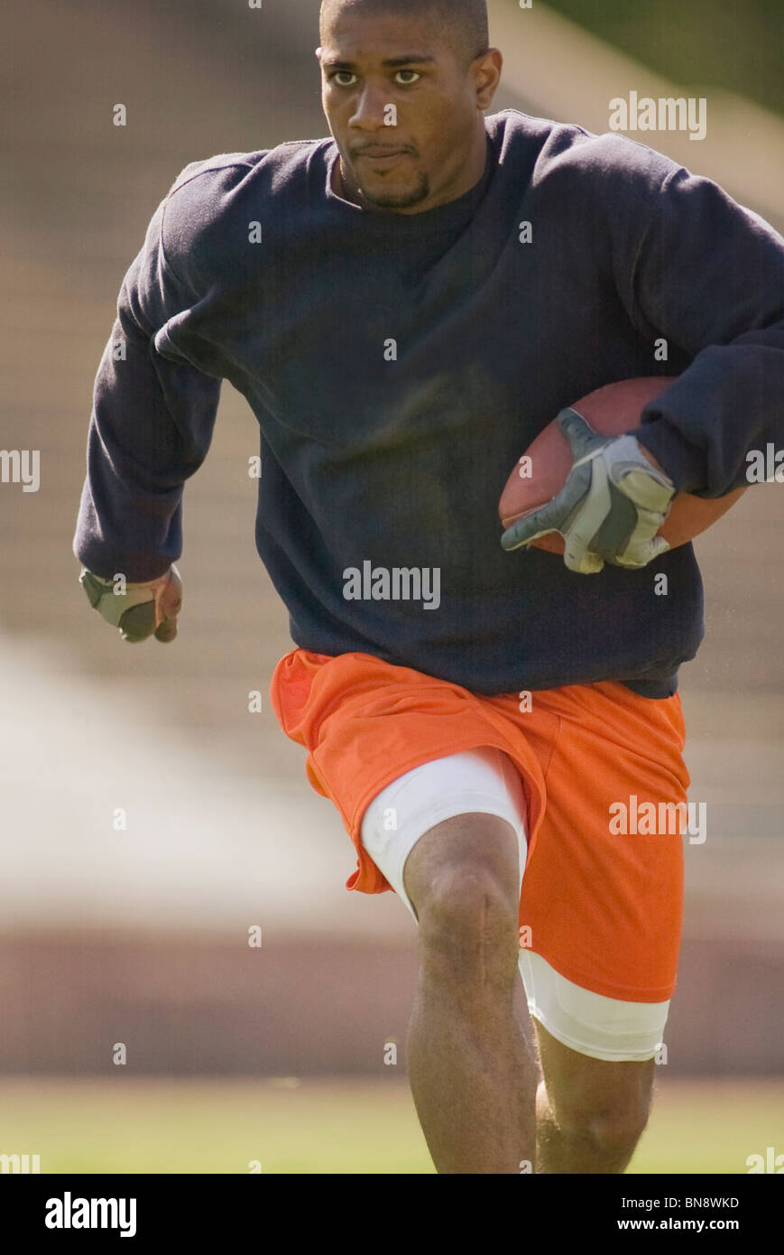 Man running with football Stock Photo